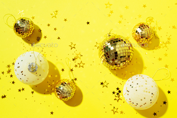 Christmas white and gold decorations, mirror disco balls, star sparkles over yellow background. Flat - Stock Photo - Images