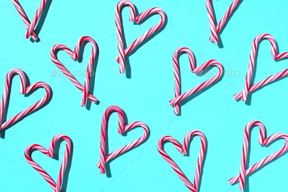 Pattern with hearts made of Christmas candy canes on blue background. Top view. Flat lay. Love - Stock Photo - Images