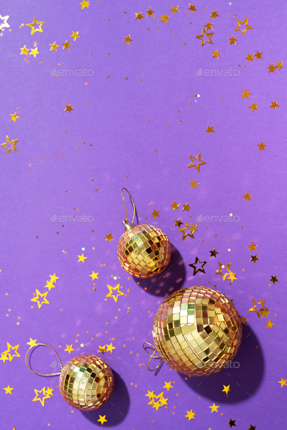 Creative Christmas concept. Shiny gold disco balls over violet background.  Flat lay, top view. New Stock Photo by jchizhe