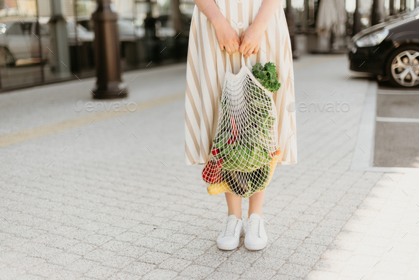 Zero waste concept with copy space. Woman holding cotton shopper and reusable mesh shopping bags - Stock Photo - Images