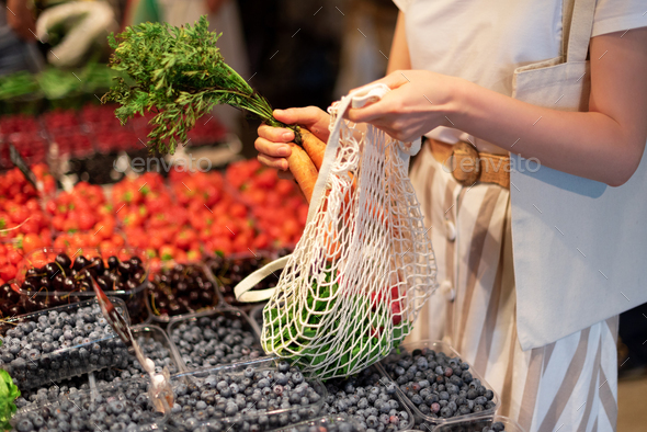 Zero waste, plastic free concept. Sustainable lifestyle. Woman chooses fruits and vegetables at