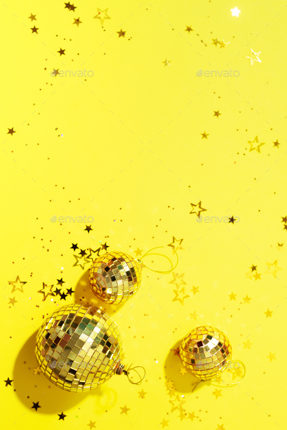 Creative Christmas concept. Shiny gold disco balls over yellow background.  Flat lay, top view. New Stock Photo by jchizhe