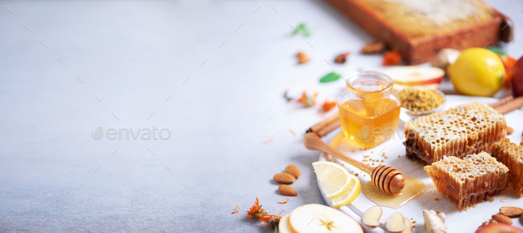 Ingredients for healthy hot drink. Lemon, ginger, mint, honey, apple and spices on grey concrete - Stock Photo - Images