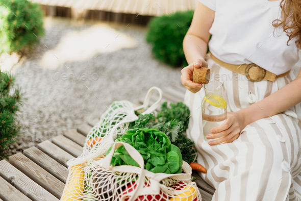 Zero waste concept with copy space. Woman holding cotton shopper and reusable mesh shopping bags - Stock Photo - Images