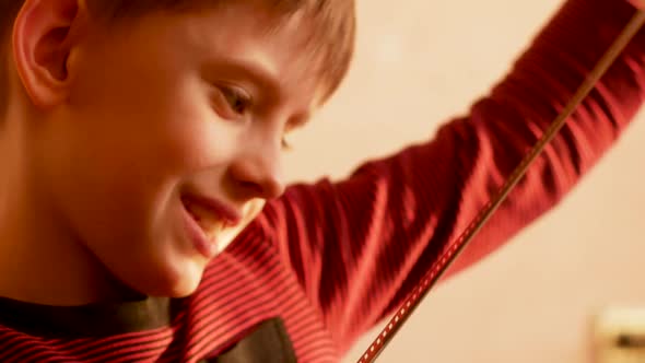 A cheerful Caucasian preschooler child examines a negative old photographic film and experiences pos alt