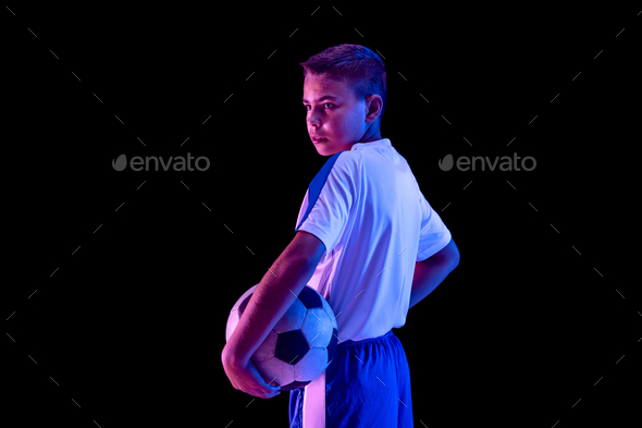 Young boy as a soccer or football player on dark studio background - Stock Photo - Images
