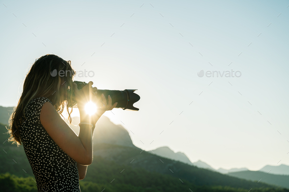Young female photographer taking photos of beautiful nature - Stock Photo - Images