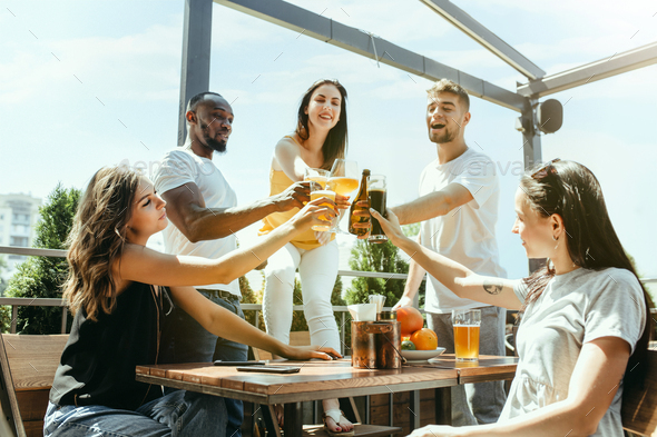 Young group of friends drinking beer and celebrating together - Stock Photo - Images