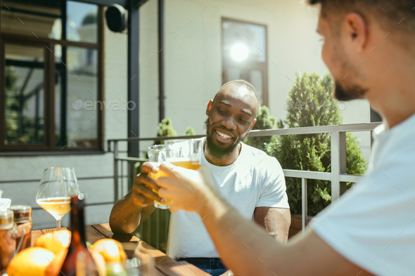 Young men drinking beer and celebrating together - Stock Photo - Images