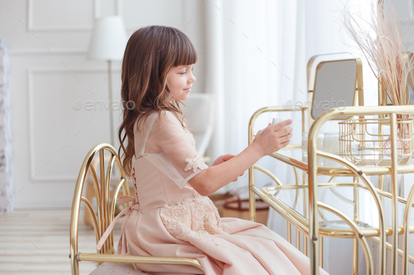 Cute little girl near oval mirror at dressing table