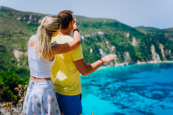 Petani view point young woman closing her boyfriend eyes in front of gorgeous seascape panorama - Stock Photo - Images