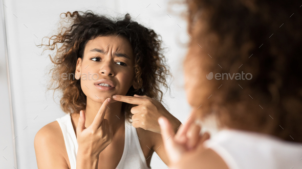 Afro Girl Squeezing Pimple Looking In Mirror In Bathroom, Panorama
