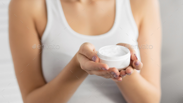 Unrecognizable Woman Holding Face Cream Jar, Gray Background, Cropped - Stock Photo - Images