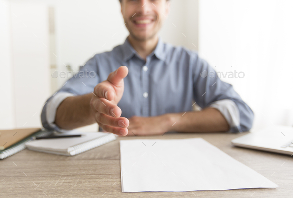 Smiling Man Stretching Hand For Handshake Sitting At Workplace, Cropped