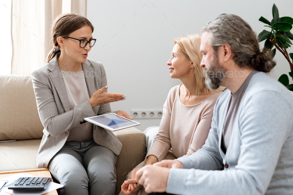 Young real estate consultant explaining her clients principles of rate change - Stock Photo - Images