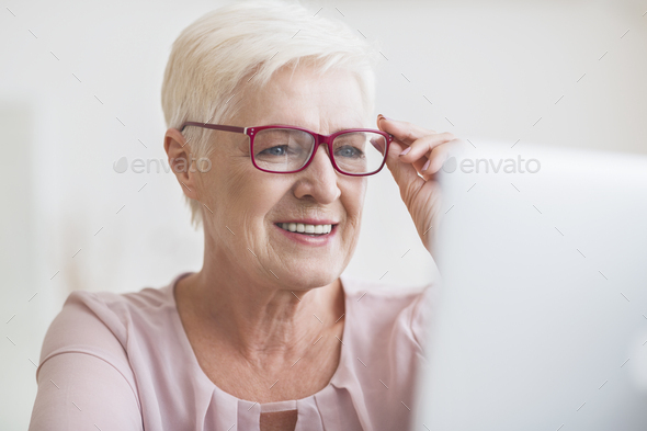 Senior business lady enjoying her new stylish eyewear - Stock Photo - Images