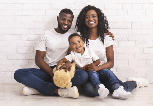 Young Black Parents And Their Son Sitting On Floor Together - Stock Photo - Images