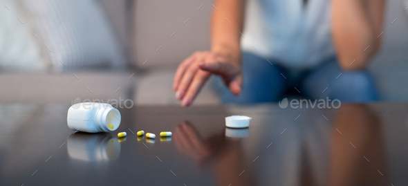 Unrecognizable Girl Reaching For Sleeping Pills Sitting On Couch Indoor
