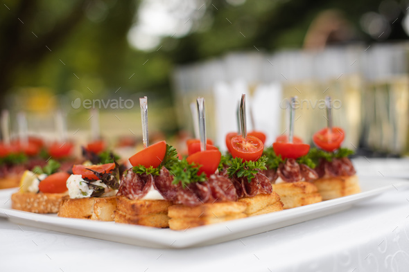 Close-up big plate with serving snack canapes fried bread tomato parsley and salami - Stock Photo - Images