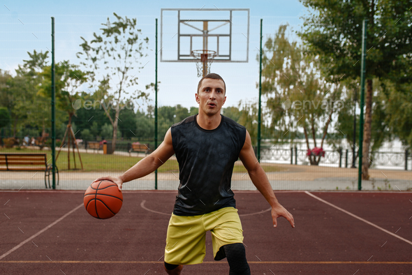 Basketball player in motion on outdoor court - Stock Photo - Images