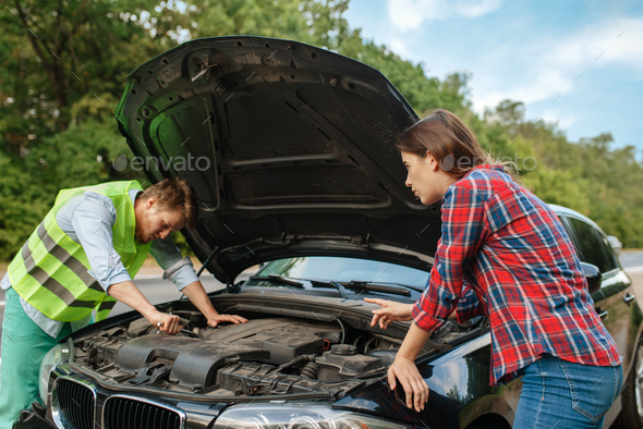 Couple at the opened hood on road, car breakdown - Stock Photo - Images