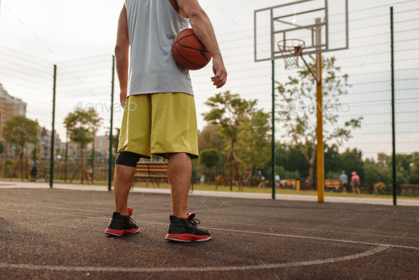 Basketball player with ball standing at the basket - Stock Photo - Images