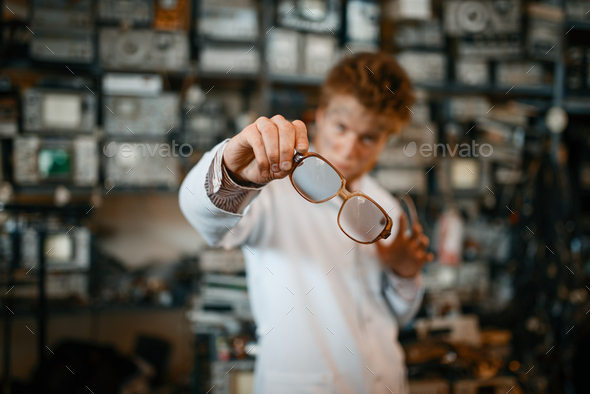 Strange scientist looks through the glasses in lab