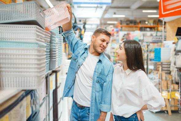 Happy buyers takes basket in hardware store