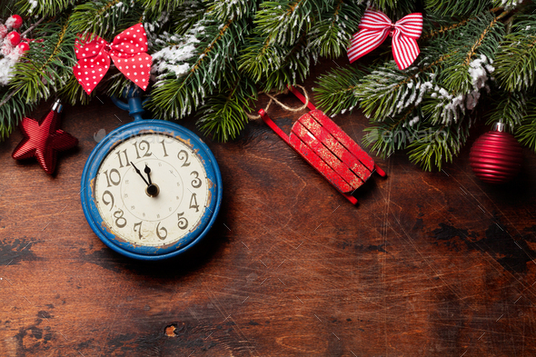 Christmas fir tree and alarm clock over old wood - Stock Photo - Images