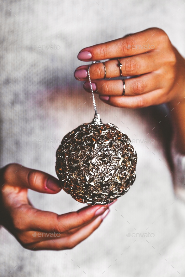 Woman in warm sweater holding toy glass decorative ball in hands, copy space. Christmas, new year - Stock Photo - Images