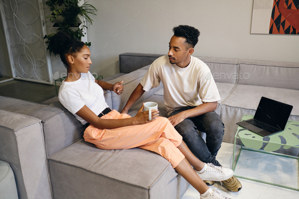 Attractive African American couple thoughtfully discussing new project on coffee break in co-working - Stock Photo - Images