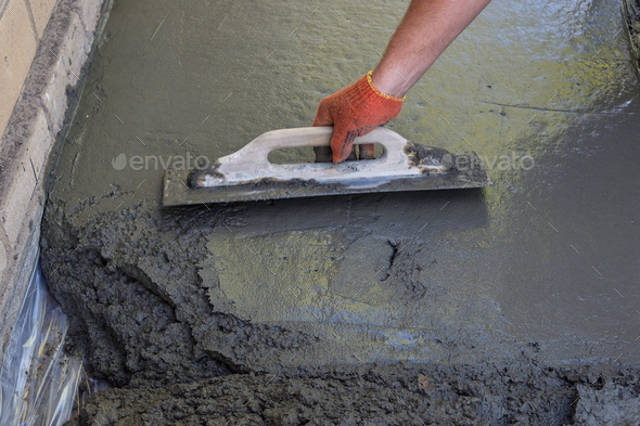 Builder smoothing the surface of screed - Stock Photo - Images