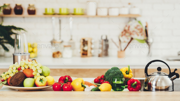 Fresh Fruits And Vegetables On Kitchen Table Stock Photo by