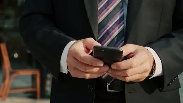 Male Reading Phone Message or Downloading an App for His Mobile Phone alt