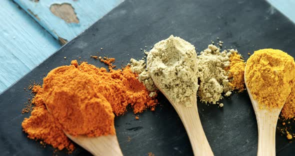 Various spice powder in wooden spoon 4k alt
