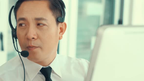 Businessman Wearing Headset Working Actively in Office alt