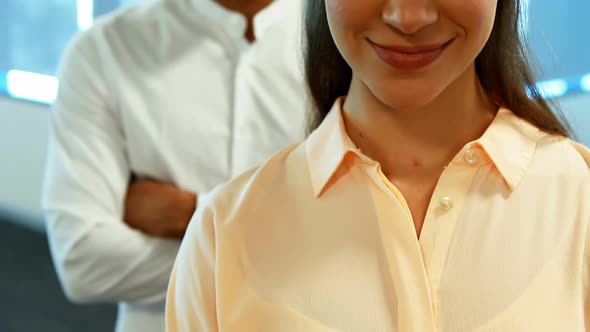 Business colleagues standing together with arms crossed in office alt