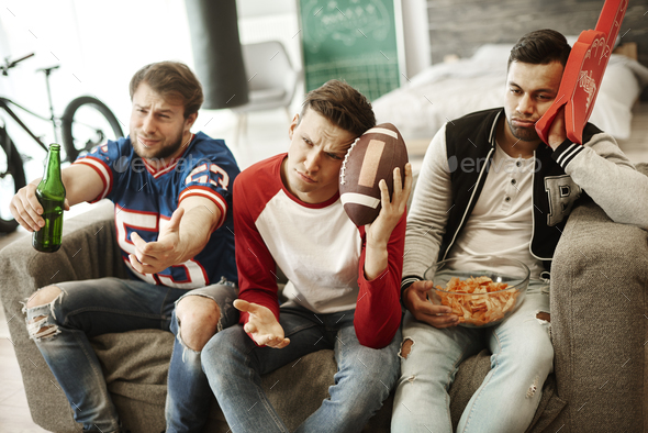 Disappointed football fans at home - Stock Photo - Images