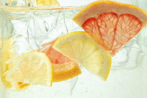 Close up view of the lemon and grapefruit slices in lemonade on background - Stock Photo - Images