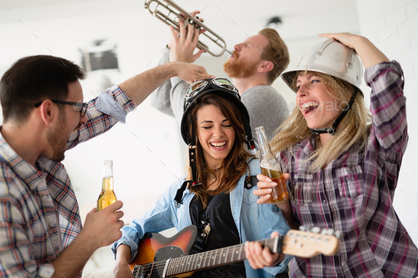 Happy group of friends playing instruments and partying