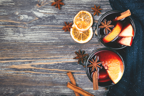 Cozy Christmas scene with two glasses of mulled wine on a wooden