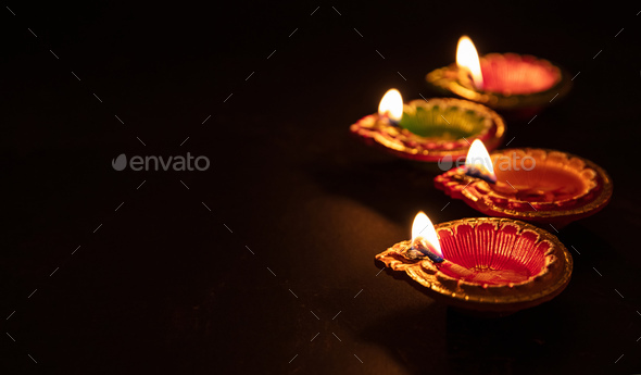 Happy Diwali. Diya colorful oil lamps, dark background Stock Photo by rawf8