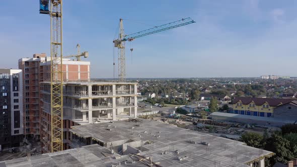 Building crane and monolituc building under construction. Construction site alt
