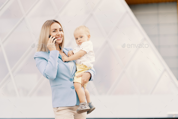Portrait of a successful business woman in blue suit with baby - Stock Photo - Images
