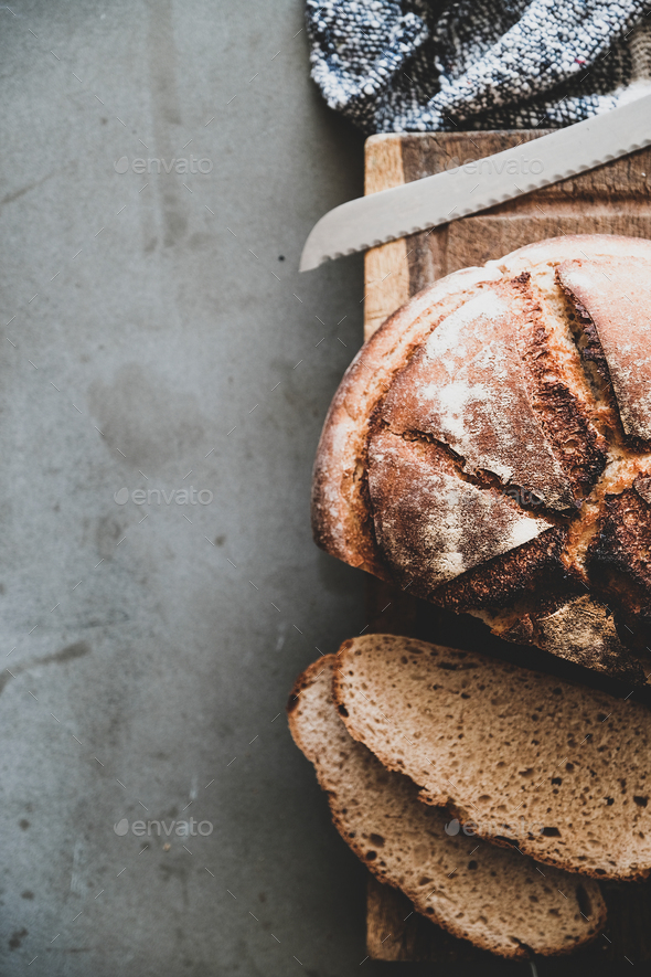 Freshly baked sourdough bread loaf and slices, vertical composition - Stock Photo - Images
