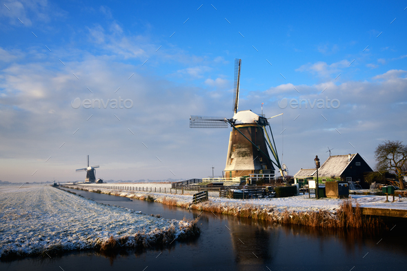 Windmills in the snow in a winter landscape at sunrise - Stock Photo - Images