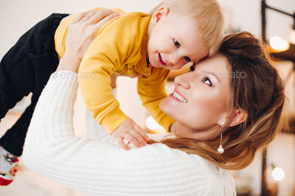 Lovely mother rising up her baby and smiling to each other - Stock Photo - Images