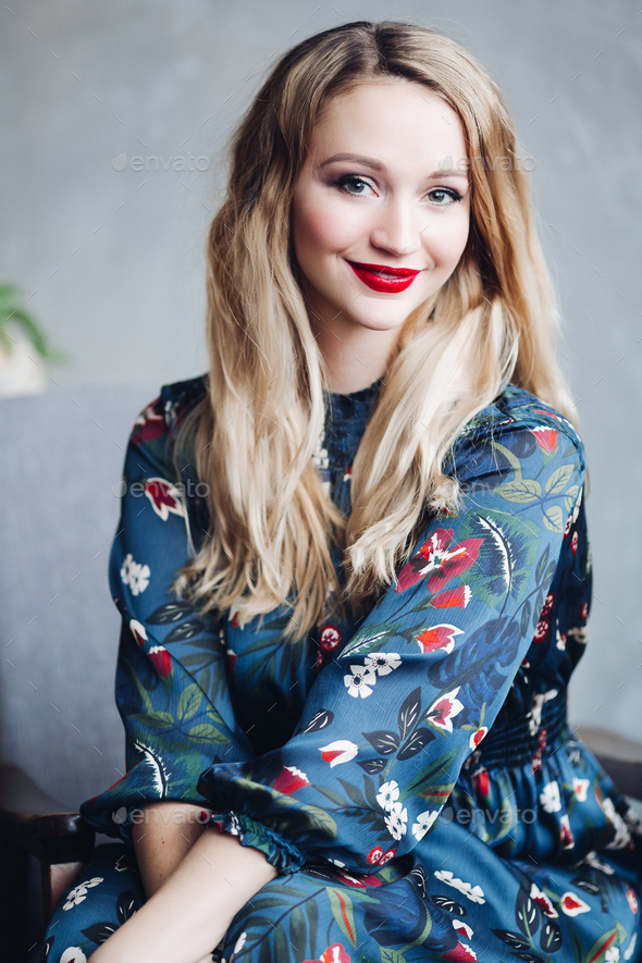 Beautiful female model in dark blue dress sitting on wooden stairs - Stock Photo - Images