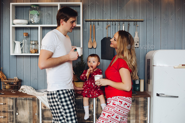 Happy family wearing Christmas pajamas cooking together with little daughter - Stock Photo - Images