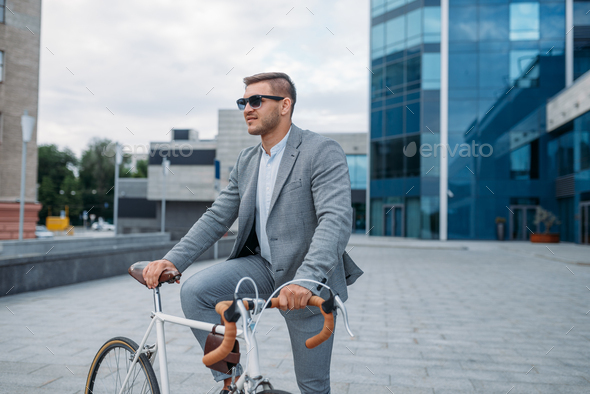 One businessman in sunglasses on bicycle, downtown - Stock Photo - Images